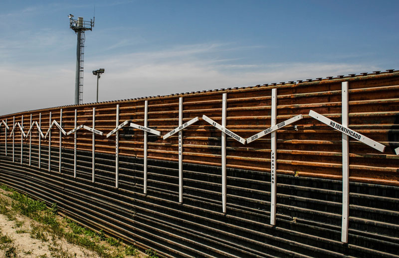 A view of a metal wall located on the San Diego, CA and Tijuana, MEX border.